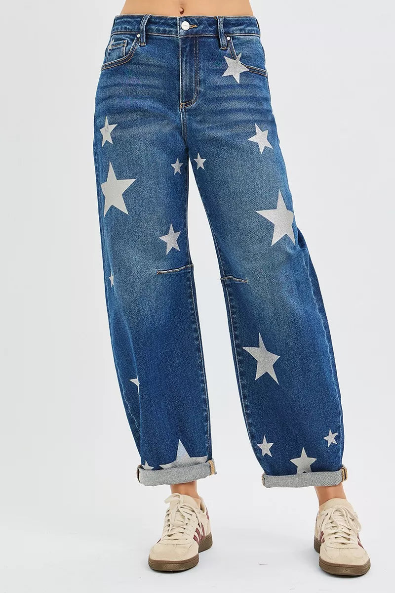 Blue jeans with star patterns worn by a person on a light gray background