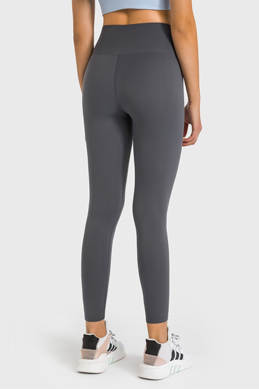 Person wearing gray leggings on a white background