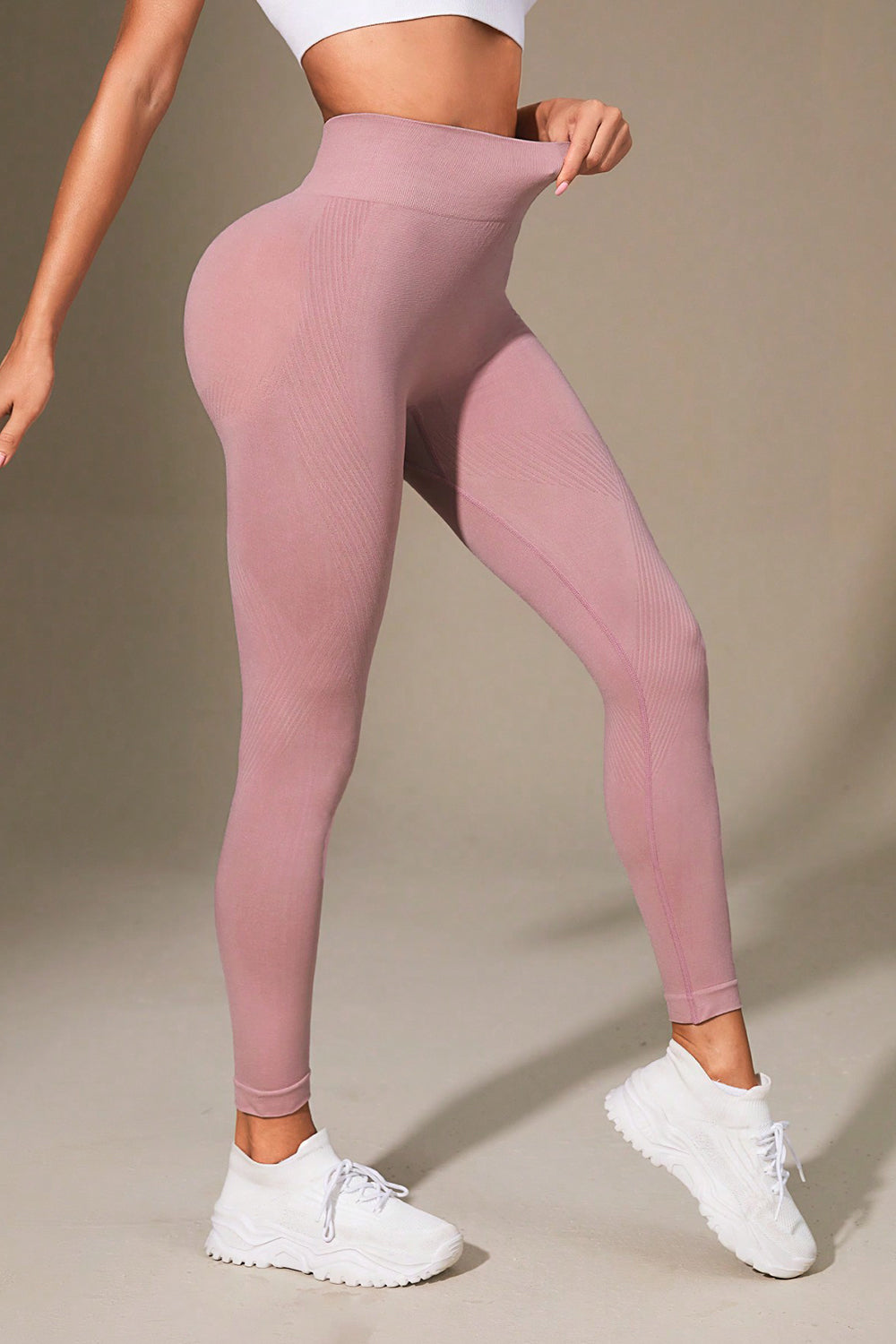 Pink leggings worn by a person on a beige background