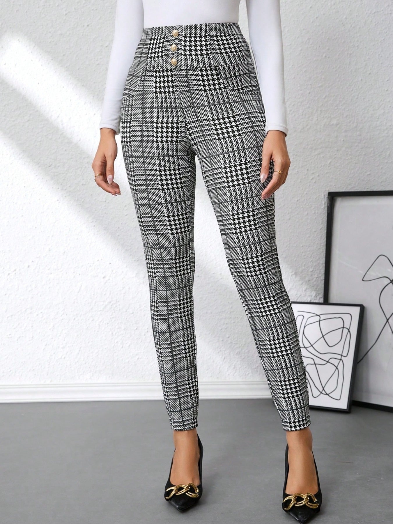 Person wearing high-waisted plaid pants with a white background