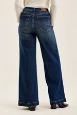 Blue jeans worn by a person on a white background