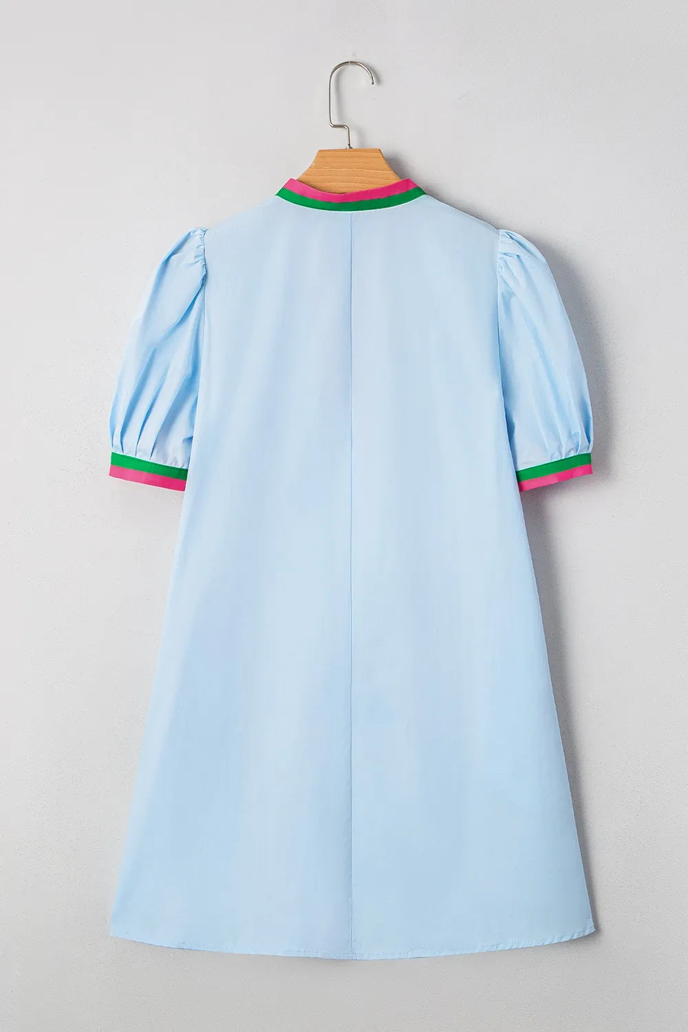 Light blue dress with colorful trim on a hanger against a plain background