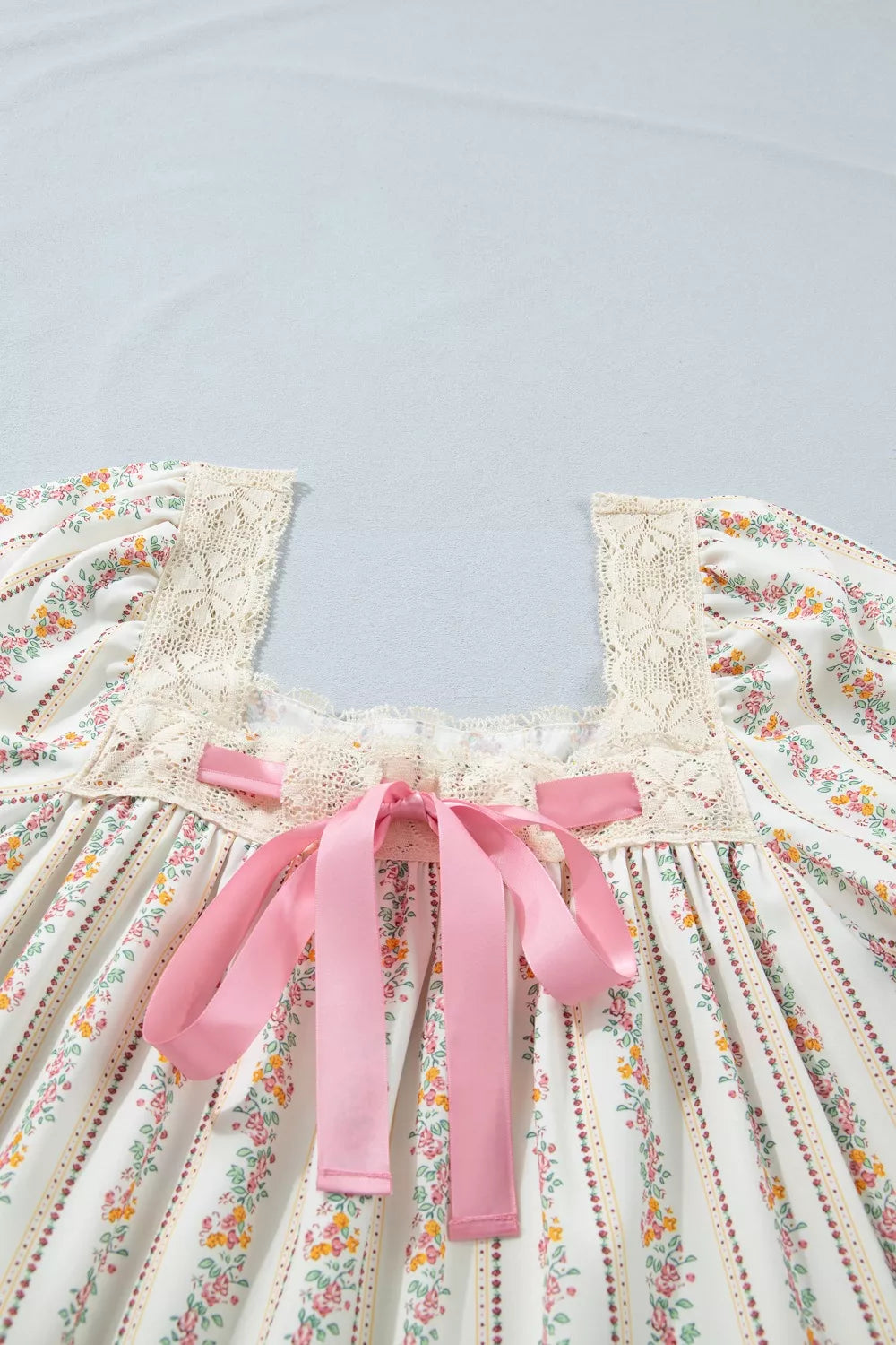Floral dress with pink ribbons on a light blue background