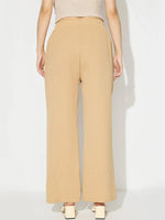 Person wearing beige high-waisted pants on a white background