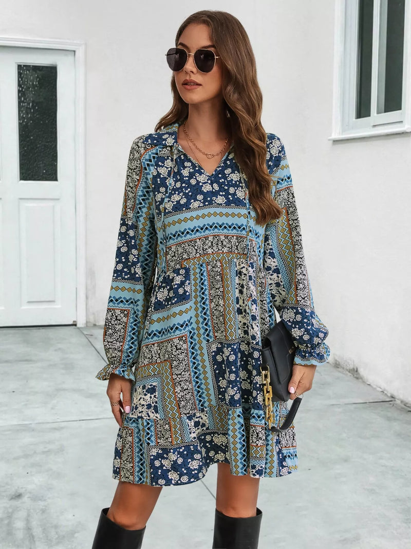 Woman wearing a patterned dress with long sleeves in an outdoor setting.