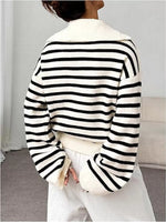Person wearing a black and white striped sweater with a plain background