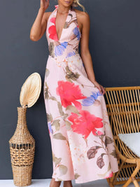 Woman wearing a floral dress with a dark gray background, wicker chair, and decorative vase.