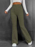 Person wearing green ribbed knit pants against a gray background