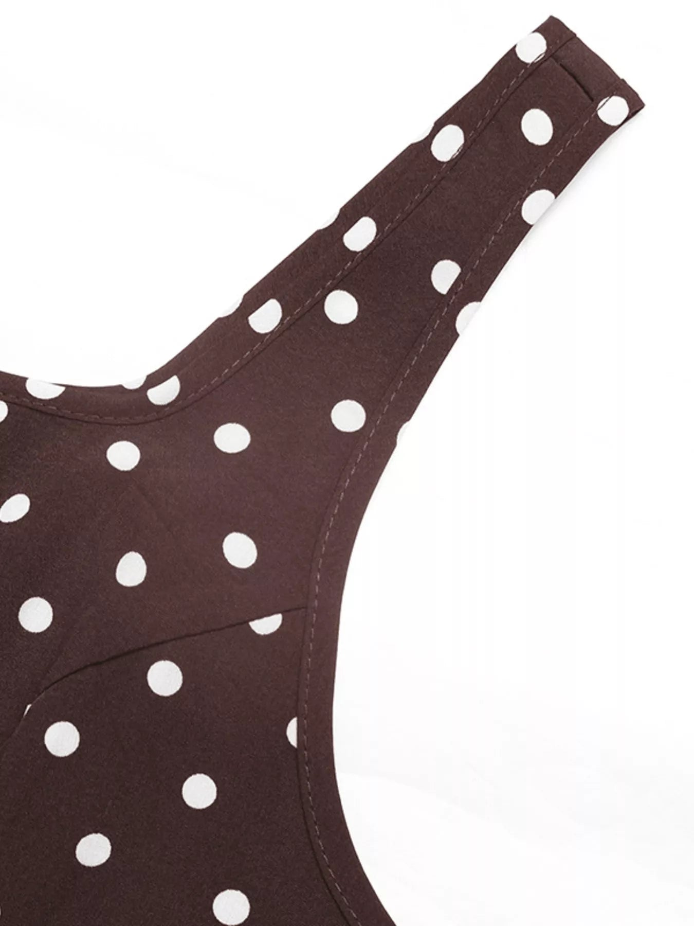Brown bikini top with white polka dots on a white background