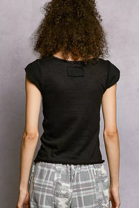 Person wearing a black t-shirt with a small logo on the back against a gray background