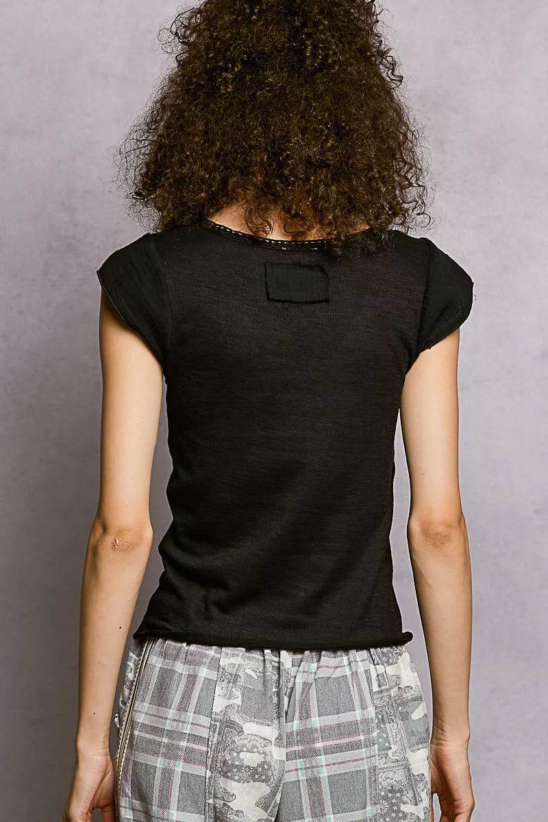 Person wearing a black t-shirt with a small logo on the back against a gray background