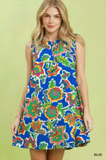 Woman wearing a colorful floral dress on a green background