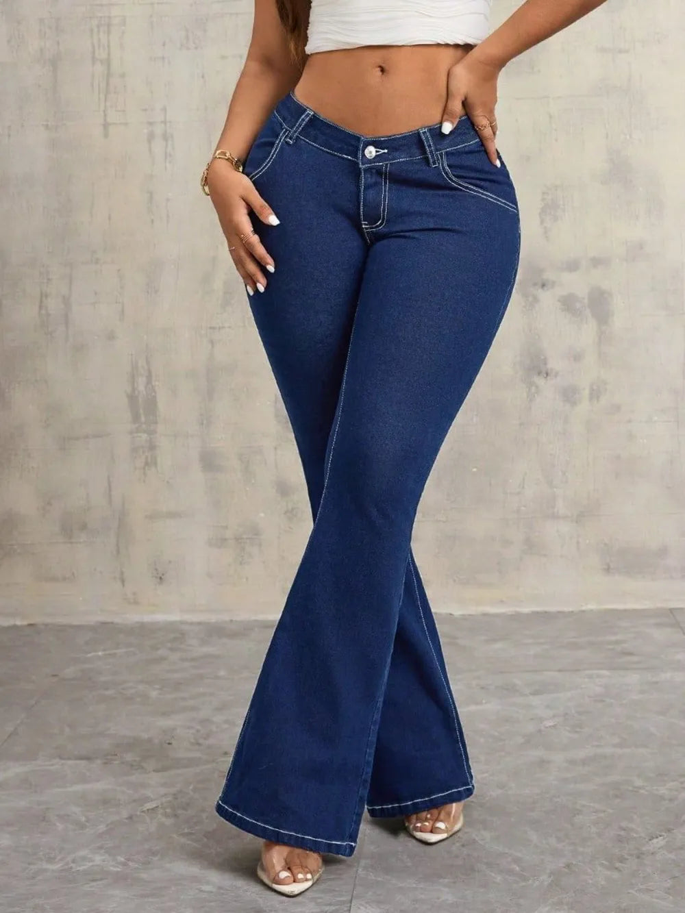 Person wearing blue flared jeans against a neutral background
