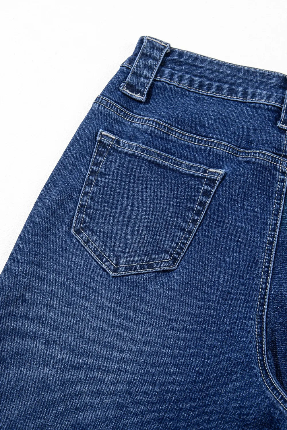 Close-up of blue denim jeans with a pocket on a white background