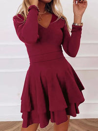 Burgundy dress with long sleeves and a flared skirt on a white background