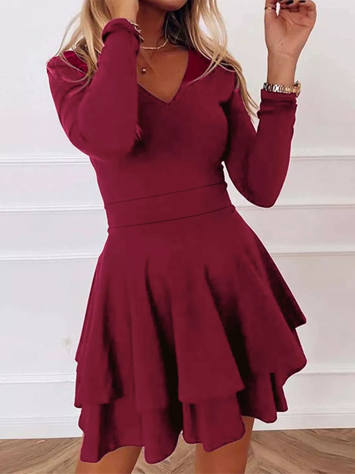 Burgundy dress with long sleeves and a flared skirt on a white background
