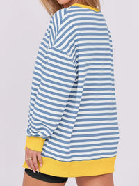 Blue and white striped shirt with yellow trim worn by a person on a light gray background