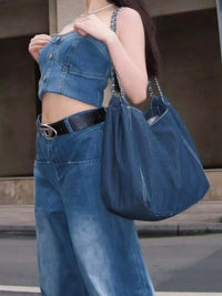Person wearing a blue denim outfit with a matching handbag.