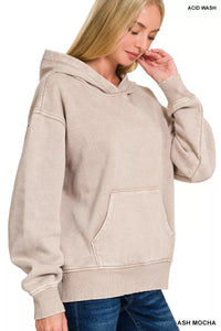 Woman wearing a beige acid wash hoodie on a white background