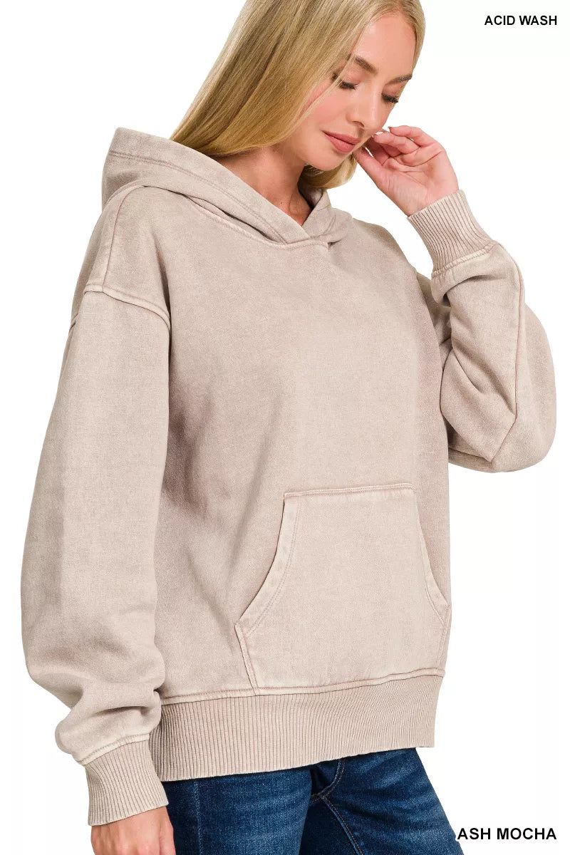 Woman wearing a beige acid wash hoodie on a white background