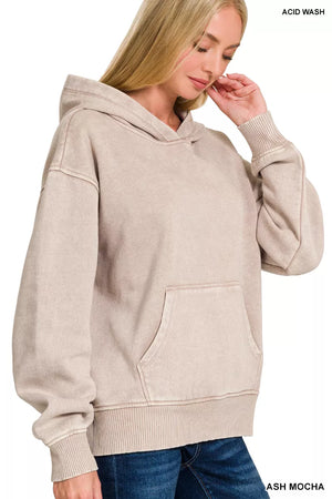 Woman wearing a beige acid wash hoodie on a white background