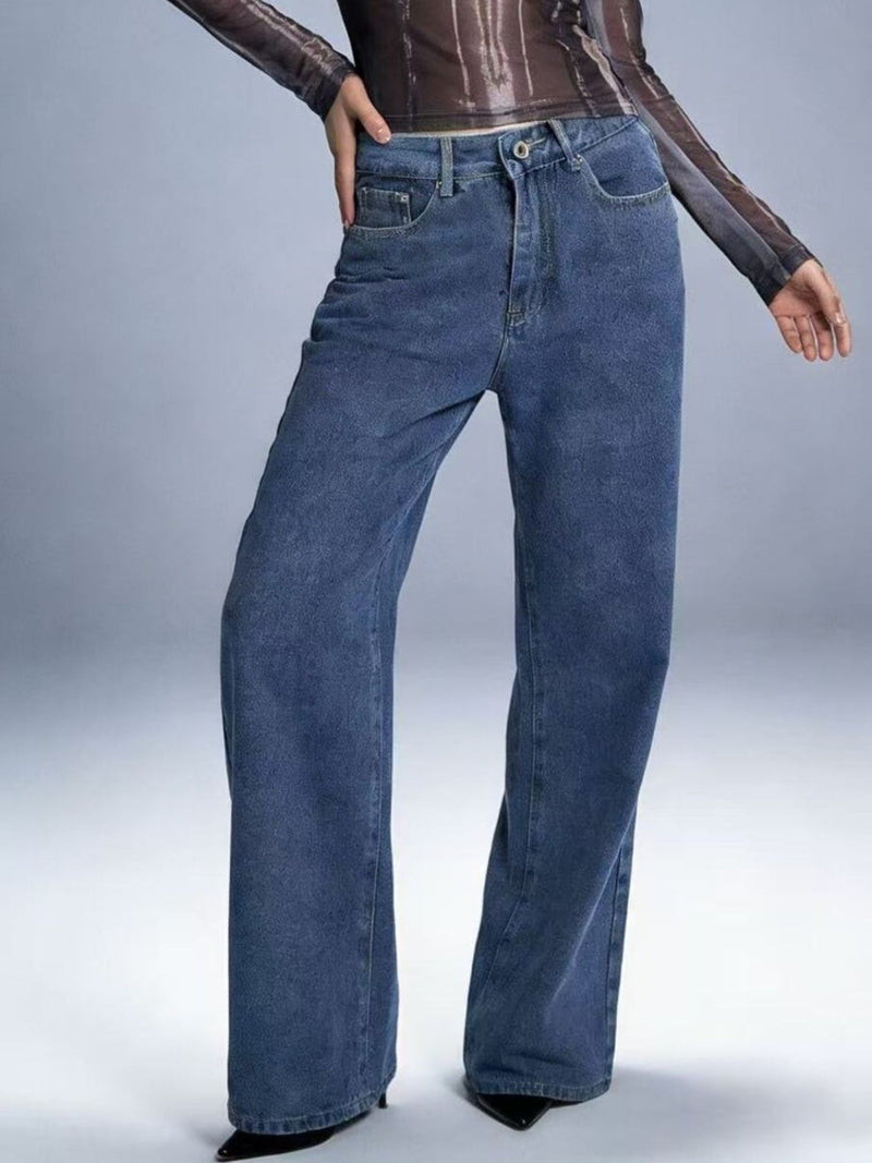 Blue jeans worn by a person on a plain background