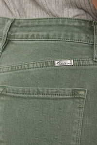 Close-up of green pants with a brand label on a blurred background