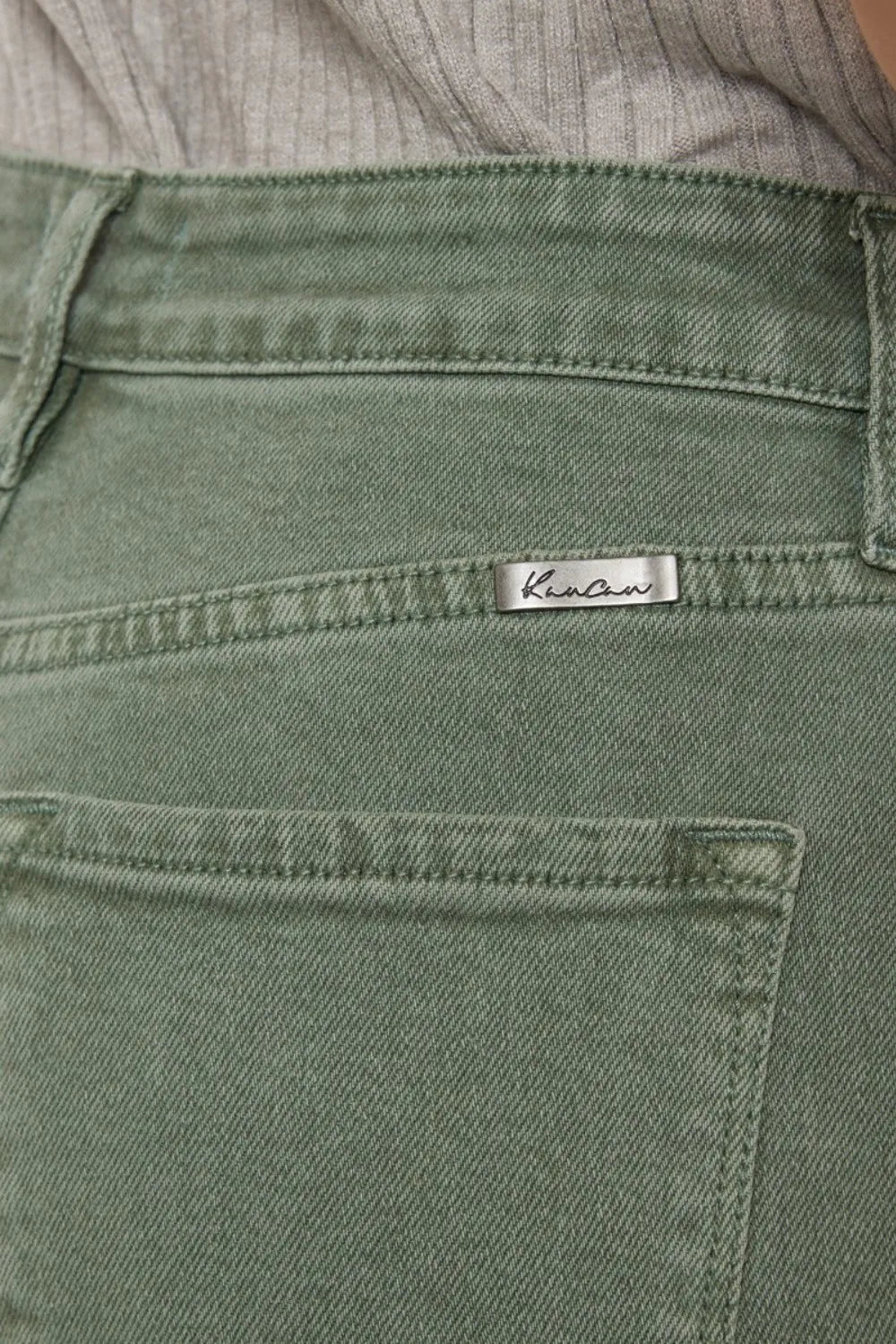 Close-up of green pants with a brand label on a blurred background