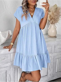 Woman wearing a light blue dress in a home setting