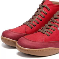 Red high-top sneakers with brown laces on a white background