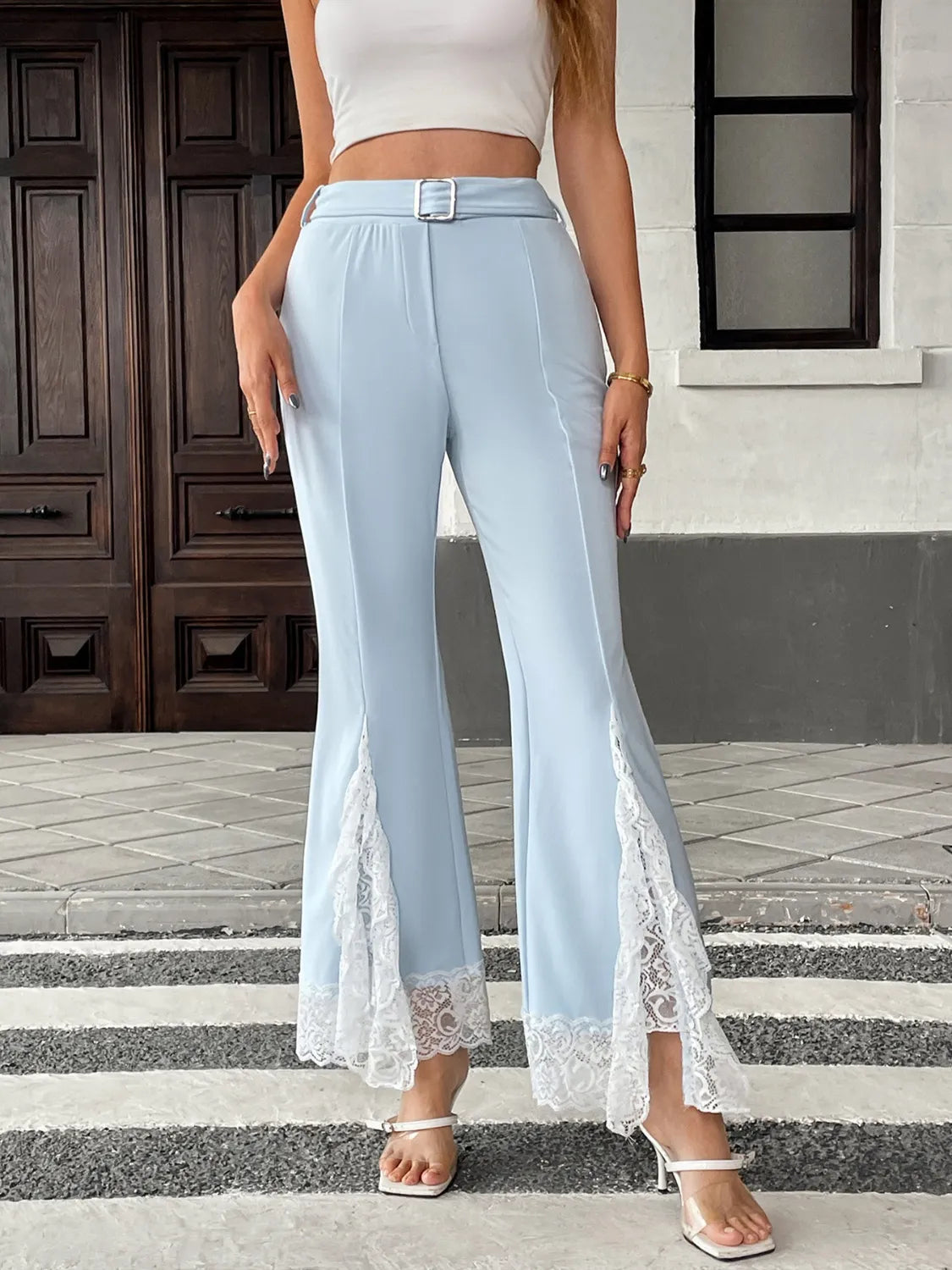 Light blue pants with lace trim worn by a person on a street.