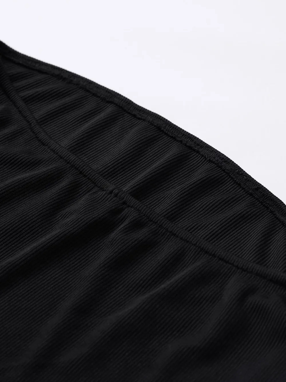 Close-up of a black pleated garment on a white background