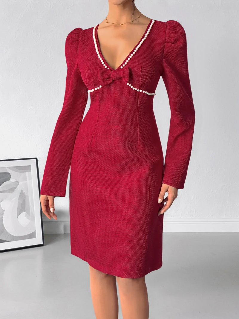 Red dress with pearl details on a white background