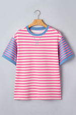 Pink and blue striped shirt on a hanger against a gray background