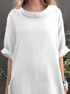 White dress worn by a person against a gray background