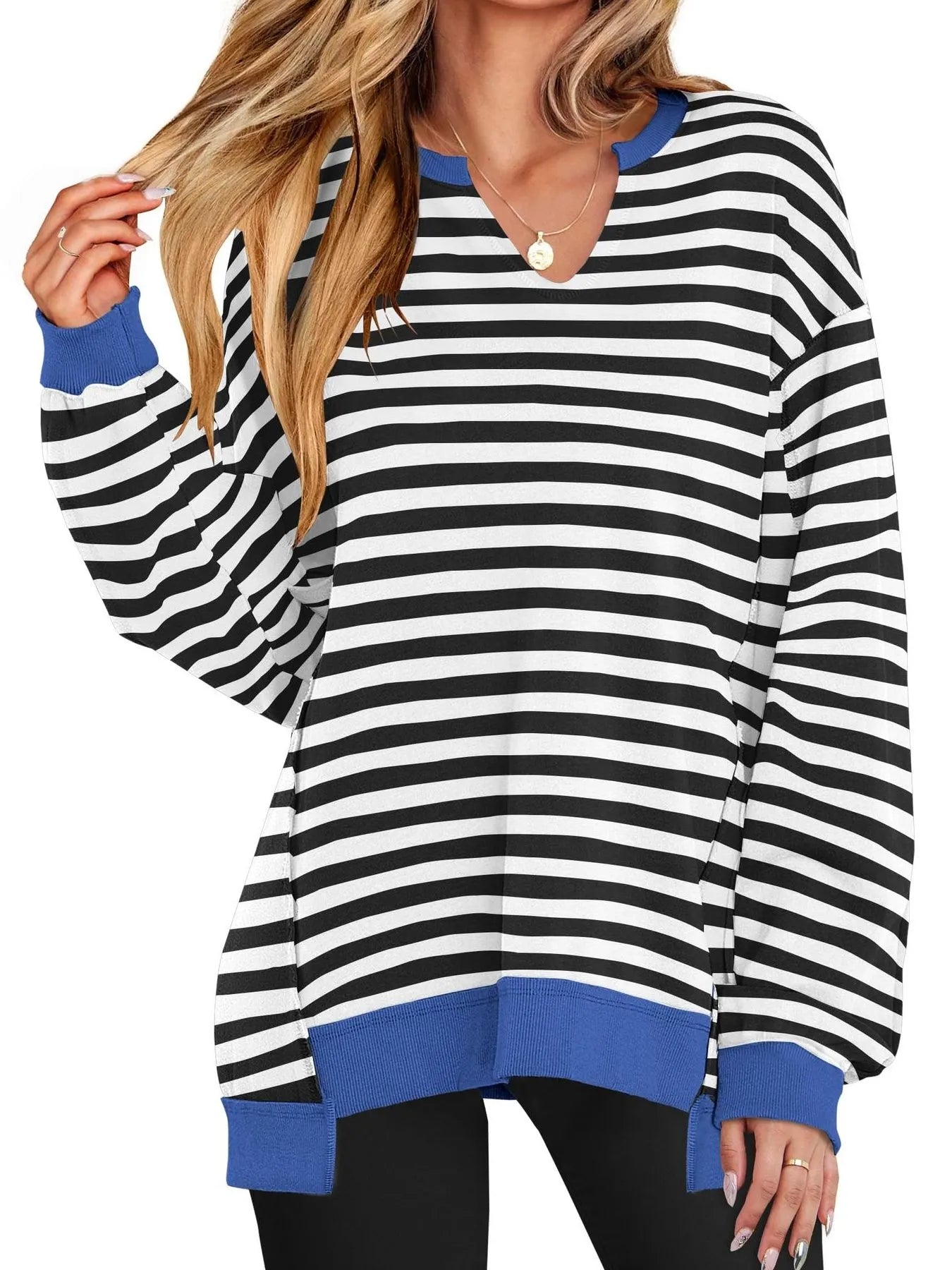 Black and white striped long-sleeve top with blue accents worn by a person on a white background