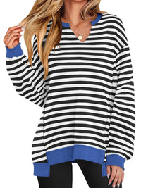 Black and white striped long-sleeve top with blue accents worn by a person on a white background