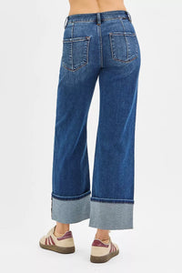 Blue jeans with cuffed hems on a white background