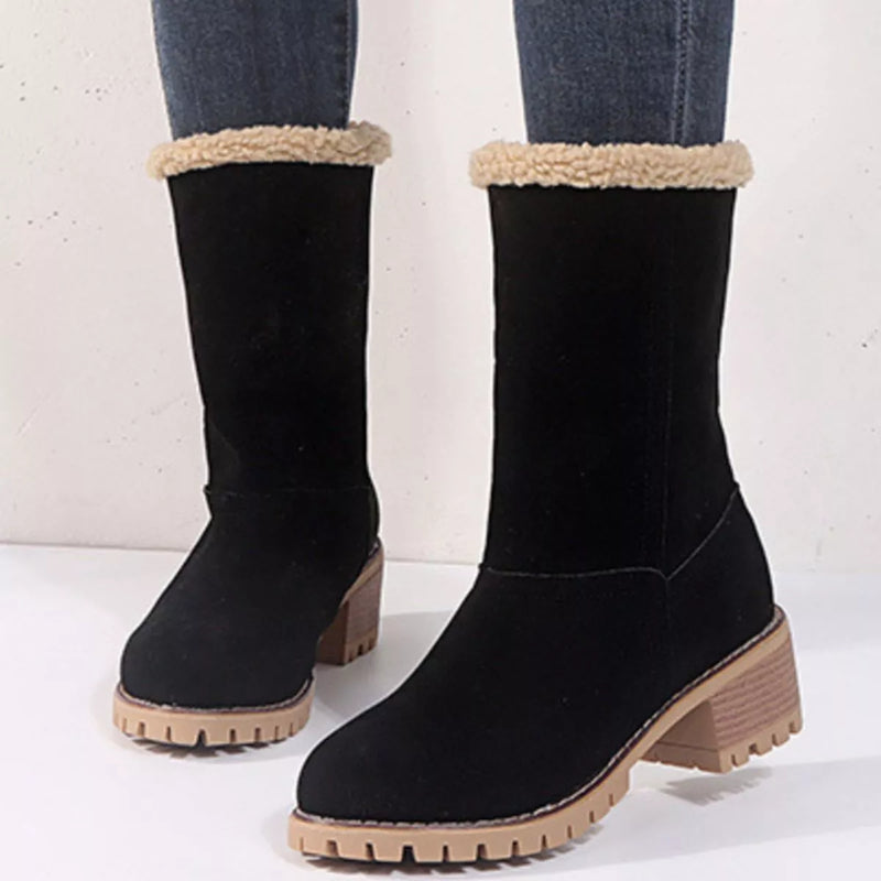 Black boots with beige fur lining and soles on a white background