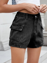 Black denim shorts worn by a person on a light background