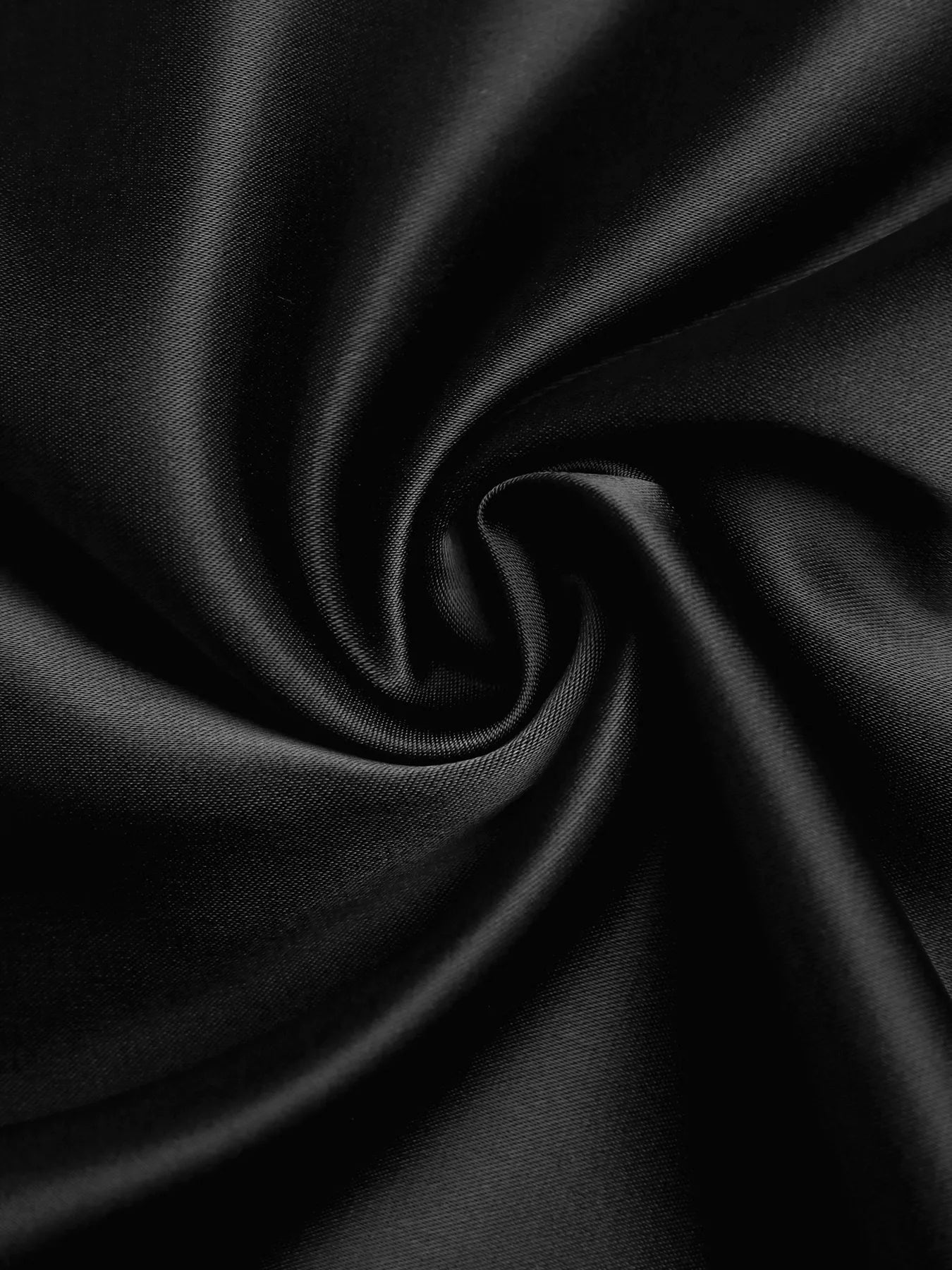 Close-up of black satin fabric with folds