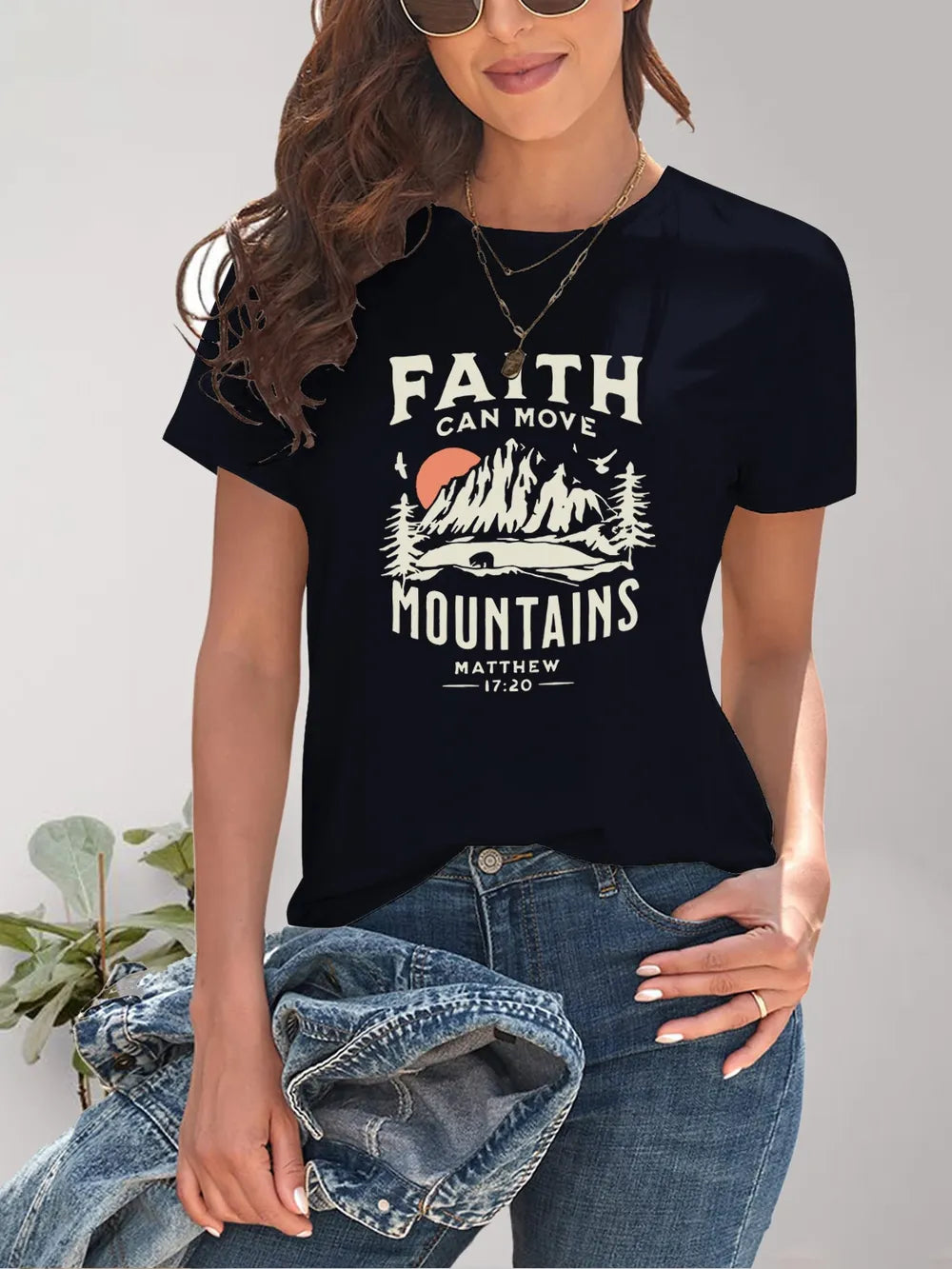 Person wearing a black t-shirt with 'Faith Can Move Mountains' graphic and text.