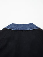 Black sweater with blue denim collar on a white background