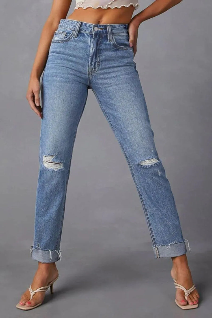 Blue jeans with slight distressing on a gray background
