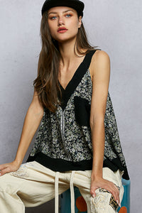 Woman wearing a floral top and cap against a gray background