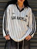 Person wearing a white and black striped shirt with 'Los Angeles' text against a metallic background
