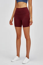 Person wearing maroon athletic shorts on a white background