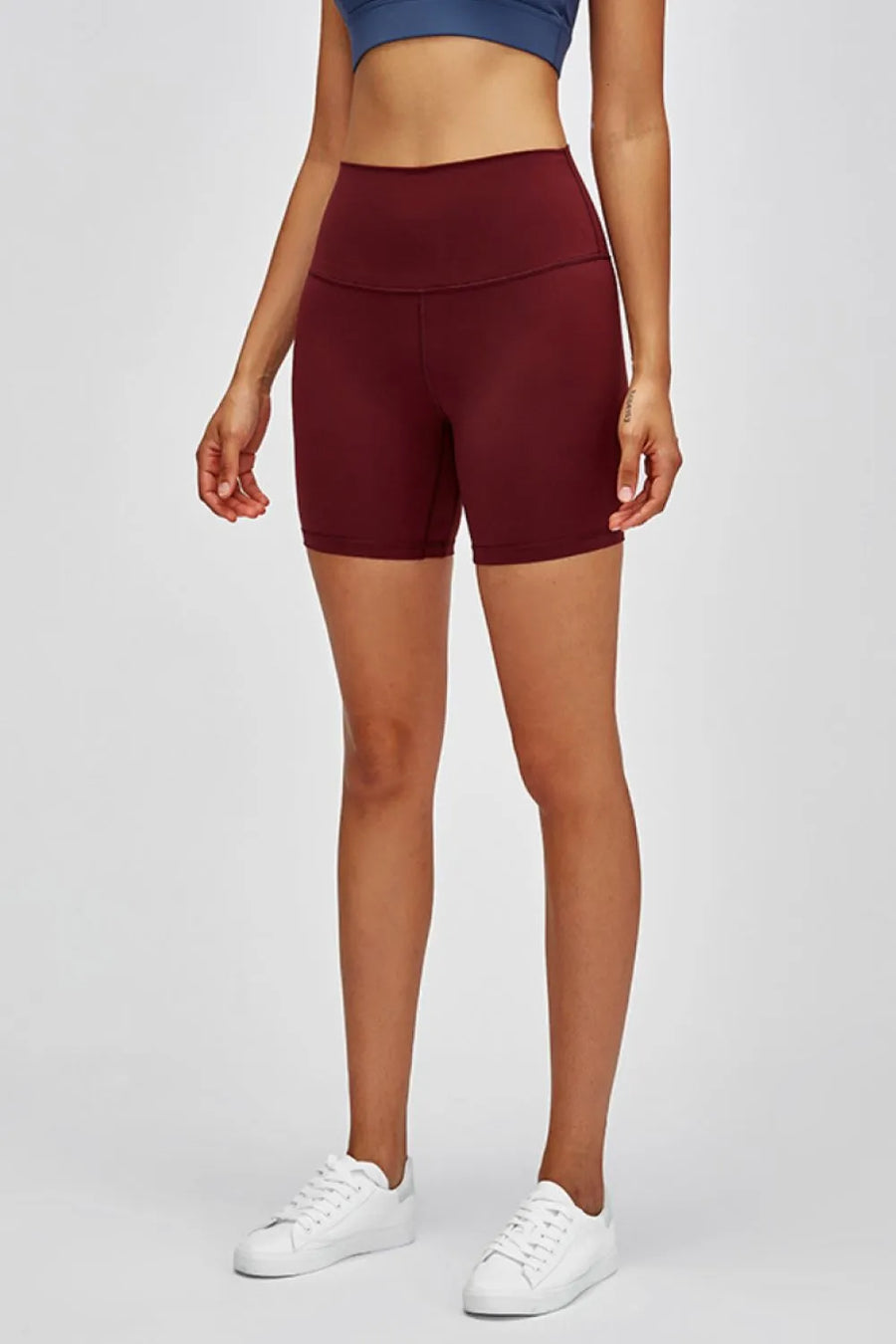 Person wearing maroon athletic shorts on a white background