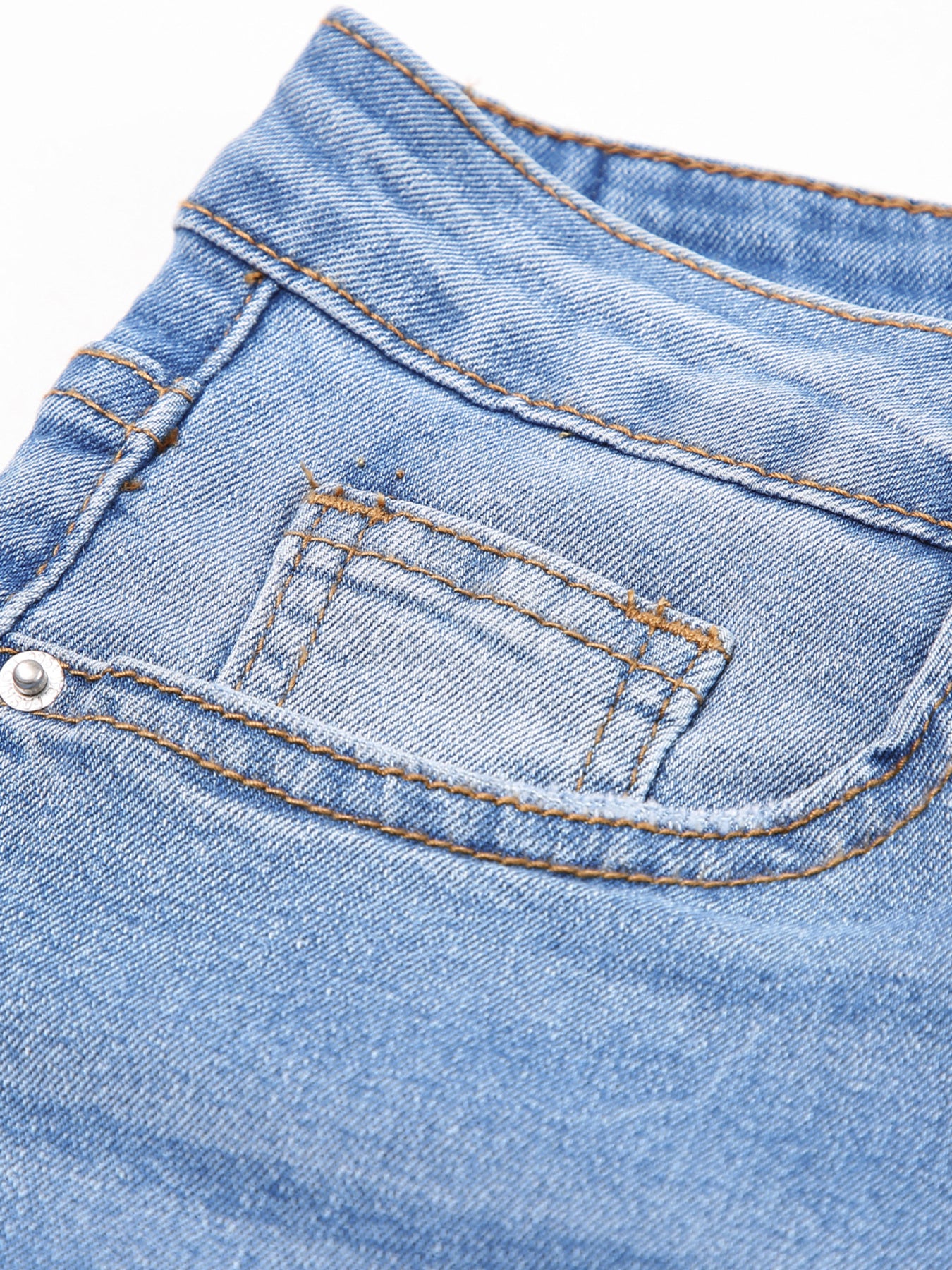 Close-up of a blue denim pocket with stitching details on a white background