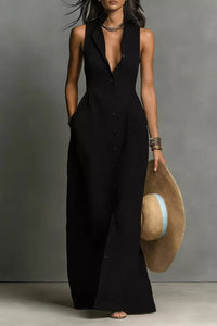 Woman wearing a long black dress holding a straw hat against a gray background